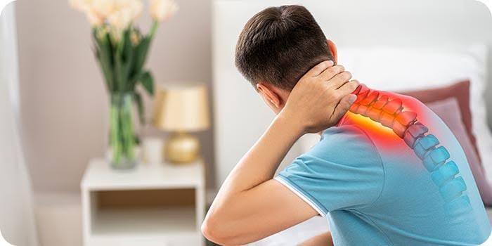 Man experiencing cervical radiculopathy symptoms with highlighted neck pain and nerve pathway, showing radiating discomfort in cervical spine area while sitting at home