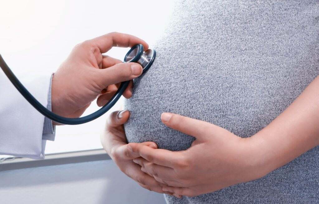 Healthcare professional using a stethoscope during pregnancy care