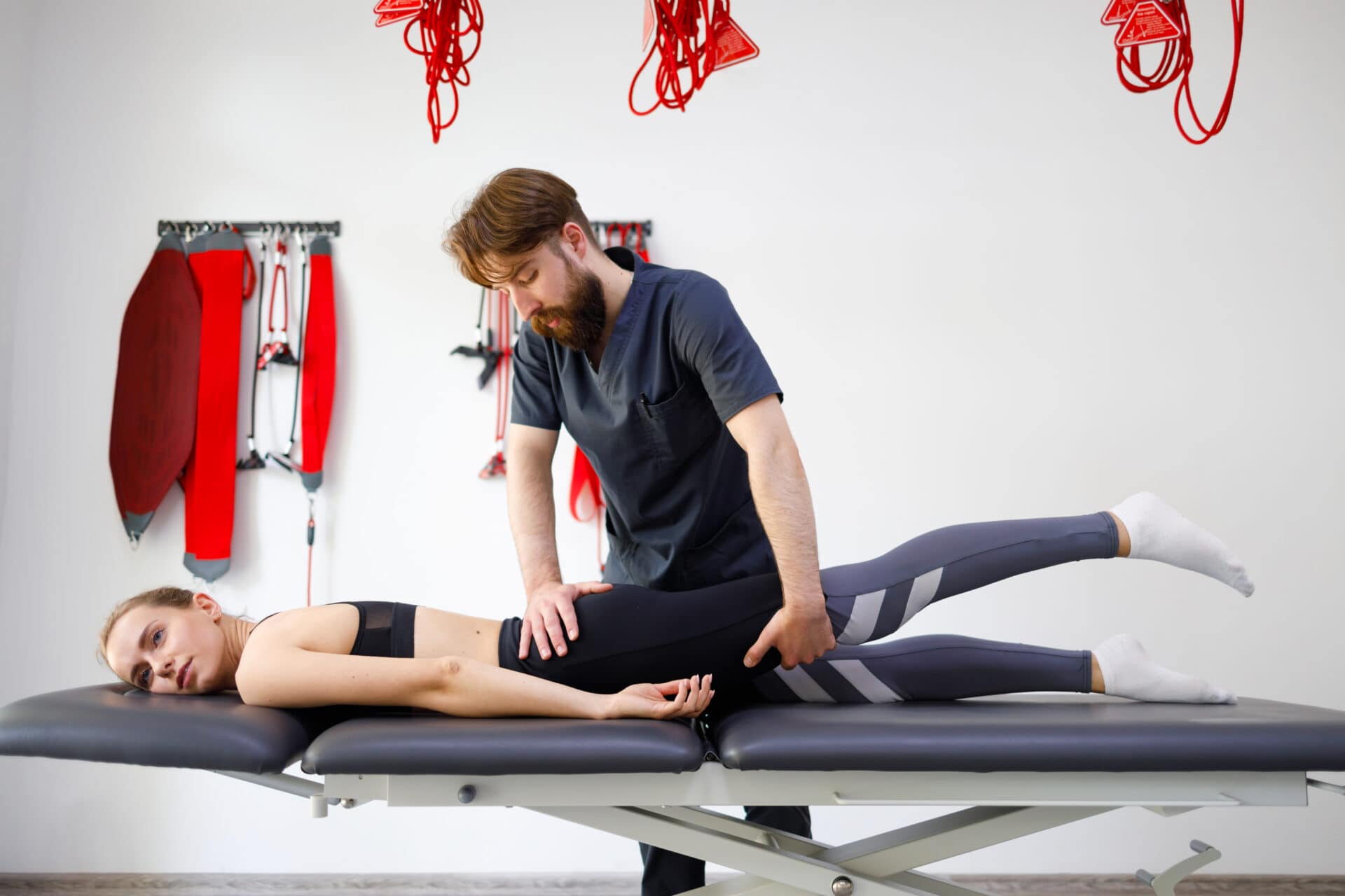 Chiropractor stretching a patient’s hip and leg during a clinic visit