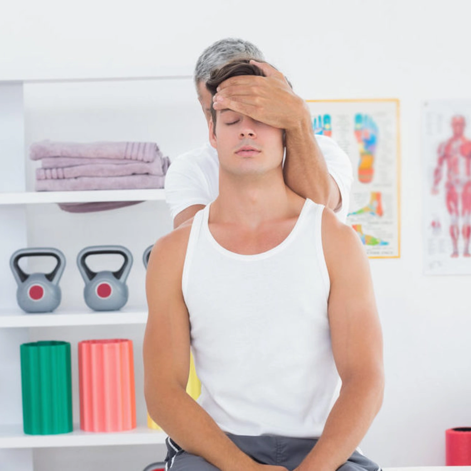 Chiropractor adjusts patient's neck in Manhattan clinic with therapy equipment in background