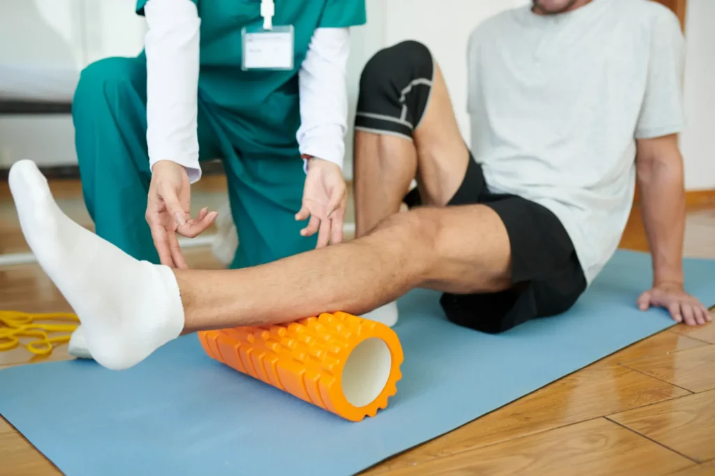 Chiropractor assists patient with foam roller therapy in Manhattan clinic