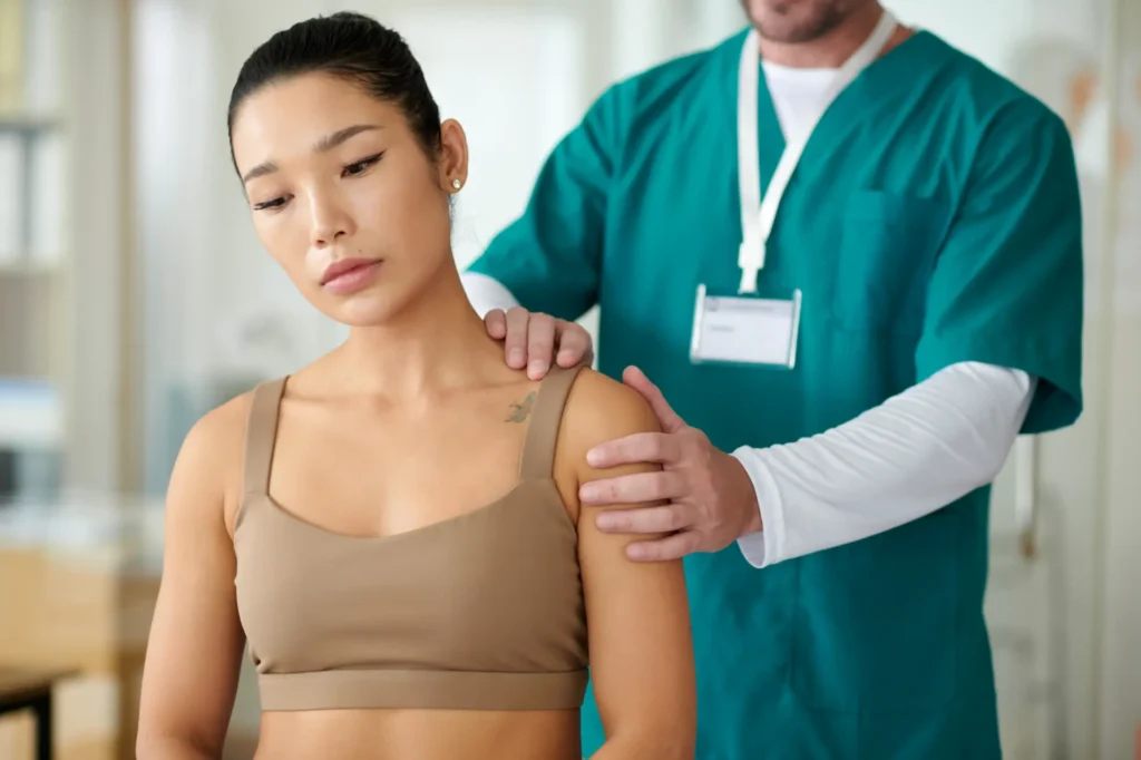 Chiropractor in NYC clinic performing shoulder adjustment therapy on patient