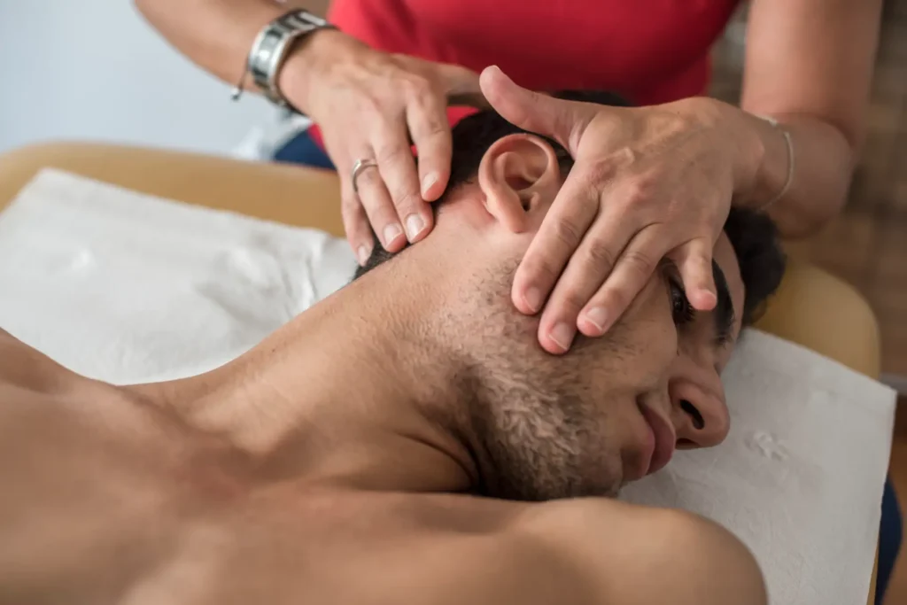 Chiropractor performing neck adjustment on patient at a Manhattan NYC clinic