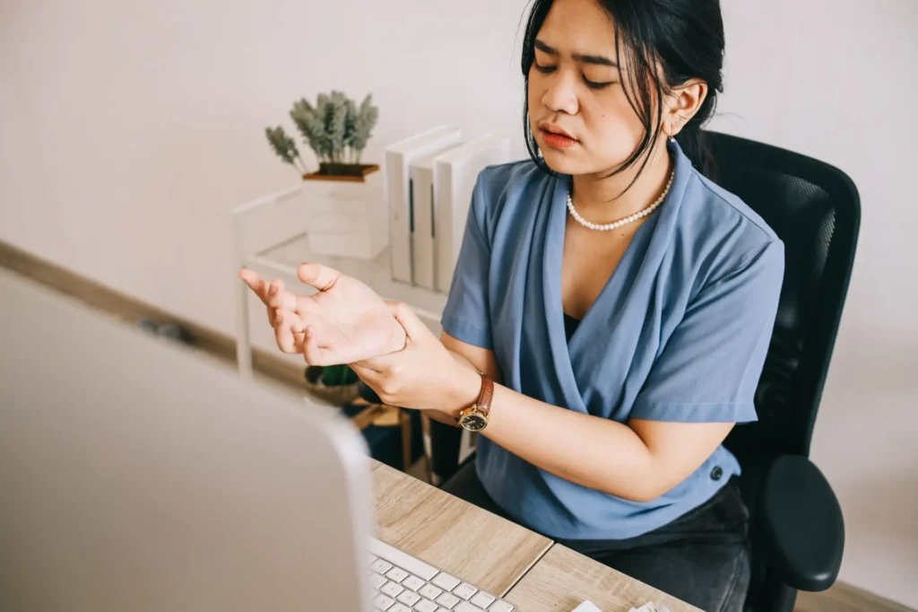 Healthcare professional in blue uniform examining wrist pain in Manhattan clinic office
