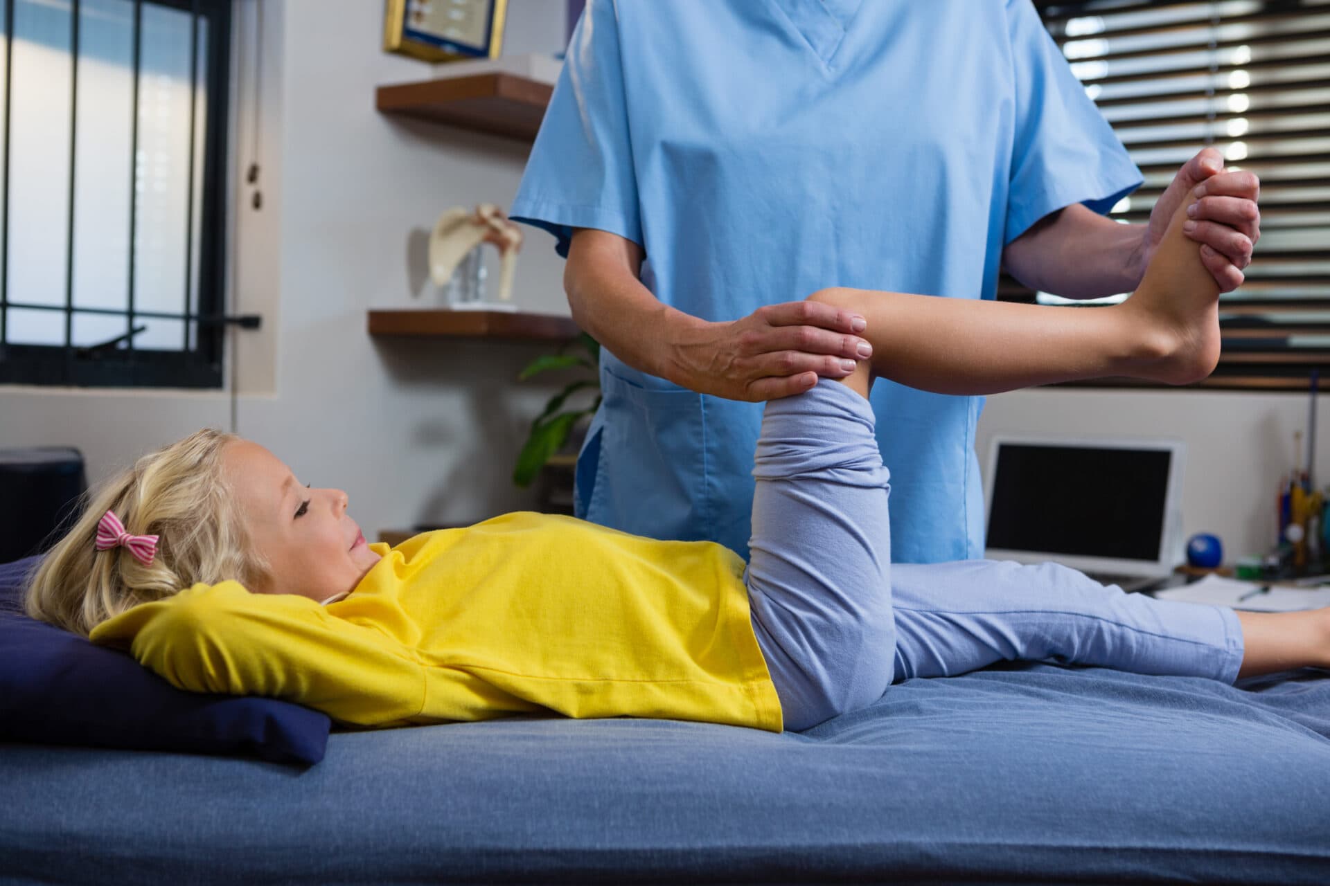 Child receiving guided leg therapy during pediatric physical therapy