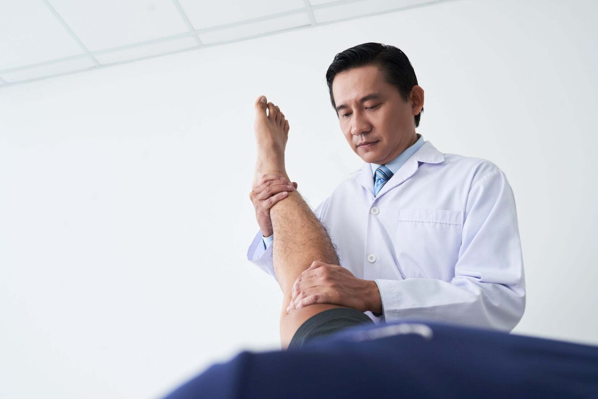 Chiropractor performs leg therapy on patient in Manhattan, NYC clinic