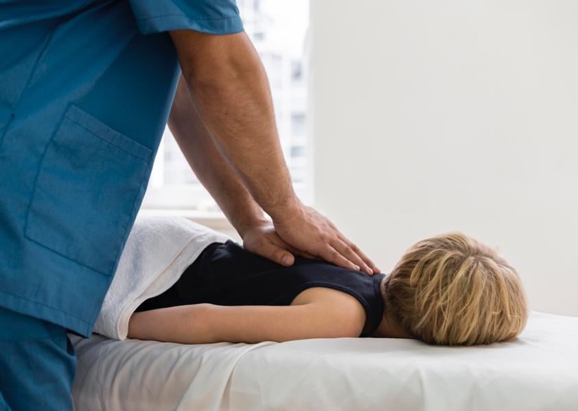 Chiropractor performing a spinal adjustment on a patient