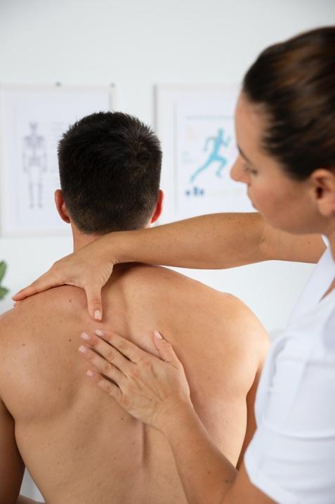 Chiropractor performing shoulder adjustment in clinic