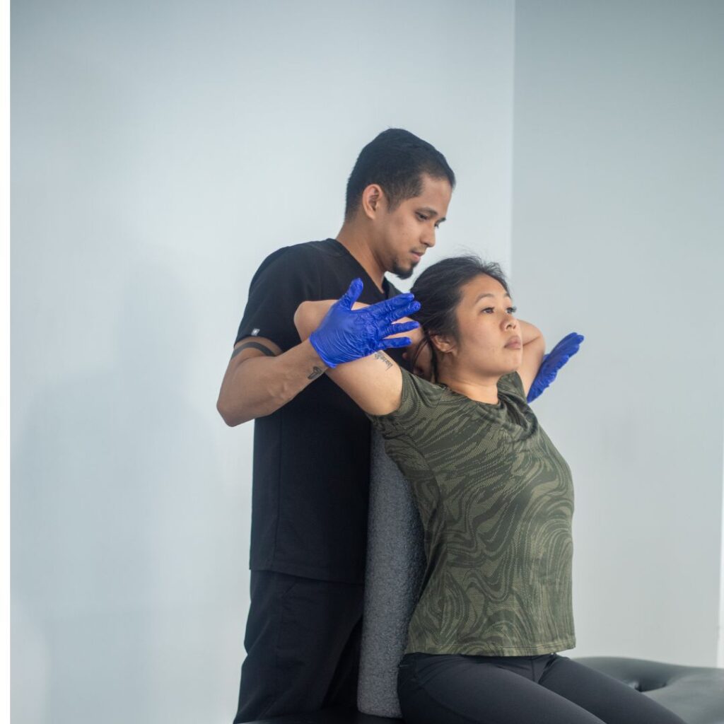 Chiropractor assists patient with shoulder therapy in Manhattan clinic, NYC