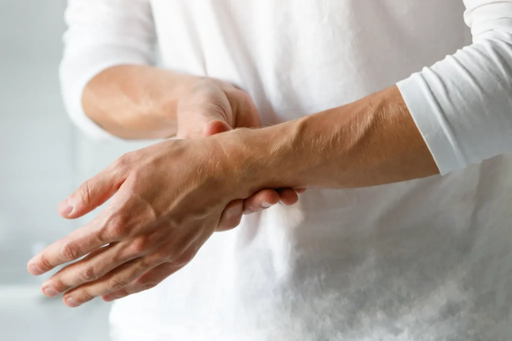 Person holding wrist, indicating pain relief treatment at a chiropractic and physical therapy clinic in Manhattan, NYC