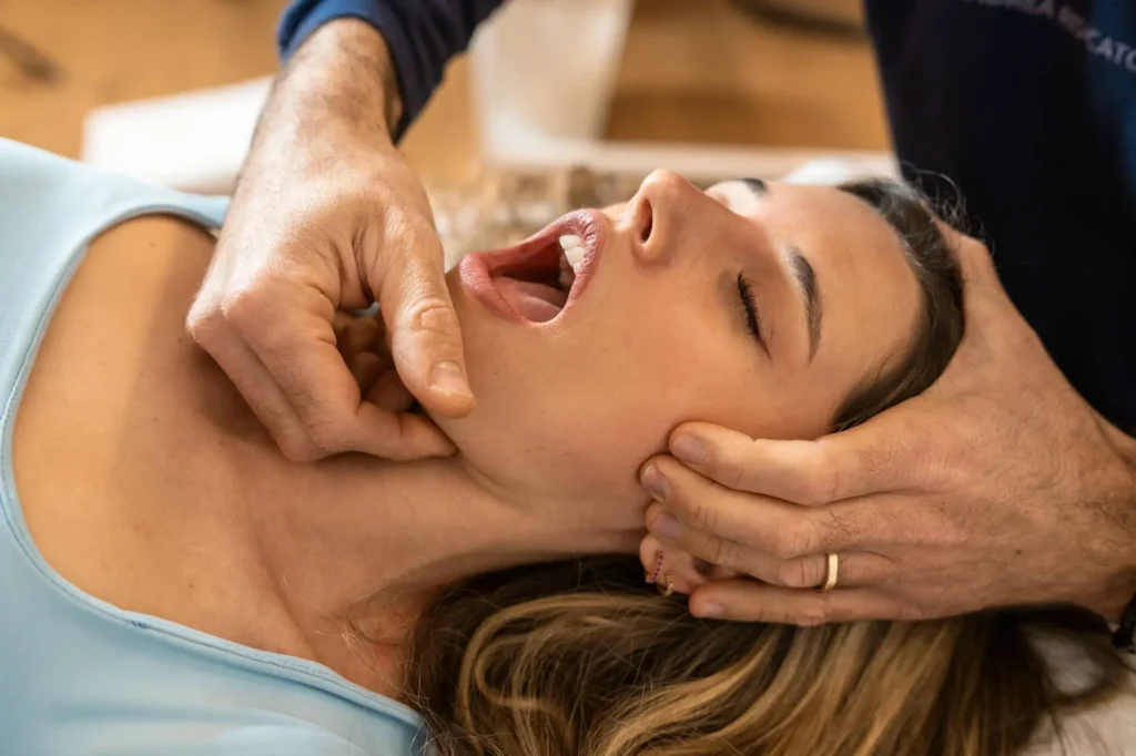 Chiropractor performing jaw adjustment therapy on a patient in a Manhattan NYC clinic