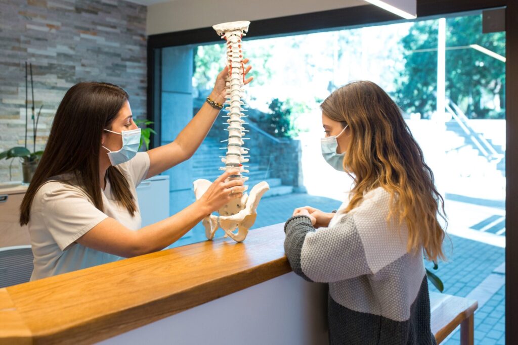 Physiotherapist showing and pointing the spinal hernia to patient