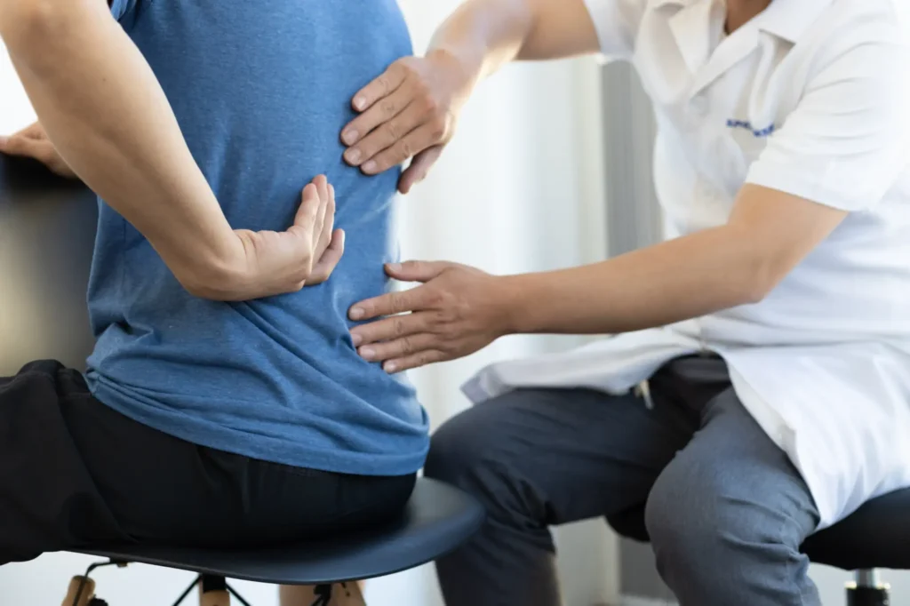 Chiropractor adjusting patient's back in Manhattan NYC clinic, focusing on spinal health and physical therapy
