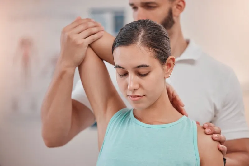 Physical therapist consulting with a woman patient in a clinic