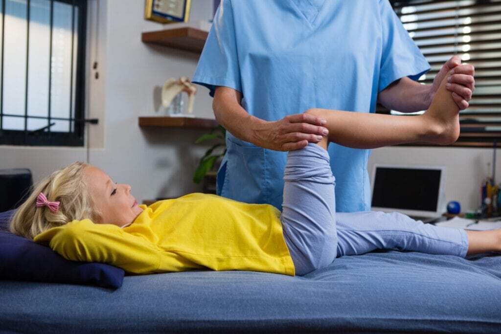 Child receiving guided leg therapy during pediatric physical therapy