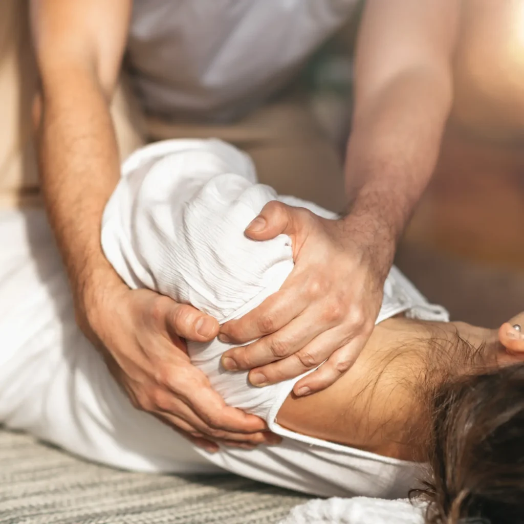 Chiropractor performing shoulder adjustment therapy in a Manhattan NYC clinic