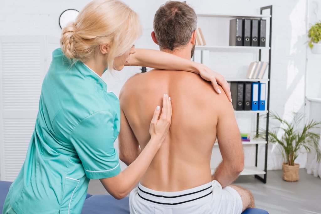 back view of man having chiropractic adjustment in clinic