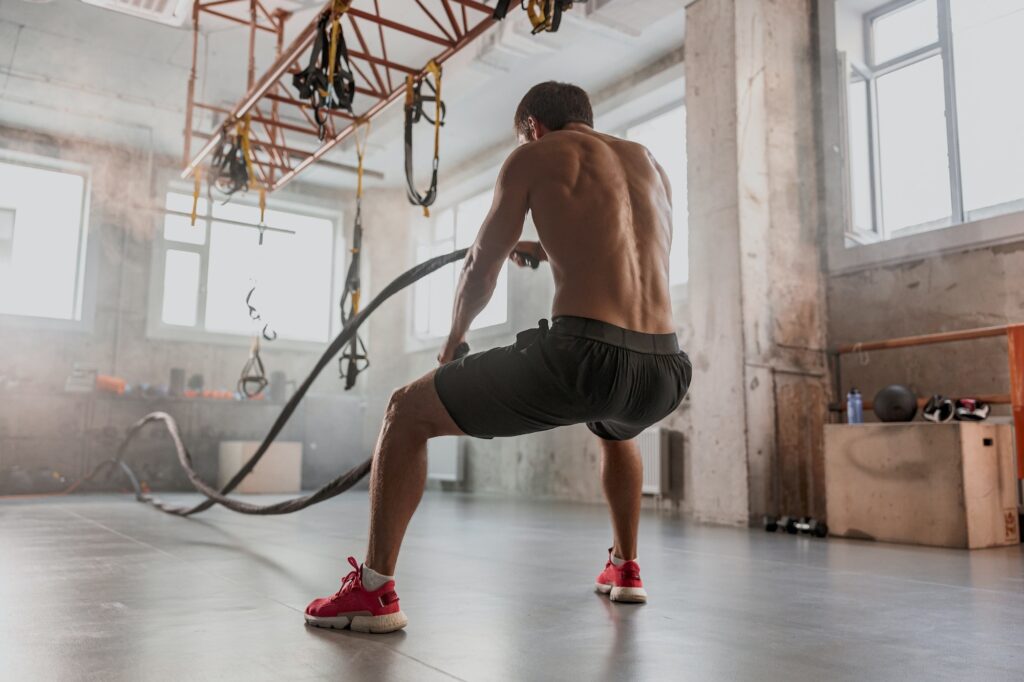 Strong muscular male exercising in sports club