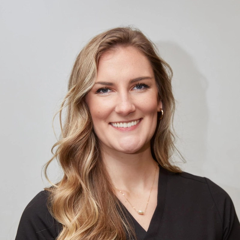 A female chiropractor smiling and looking at the camera