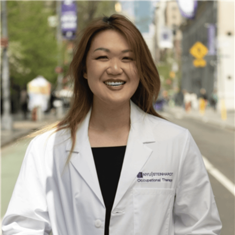 A smiling woman with an NYU Steinhart | Occupational Therapy lab coat