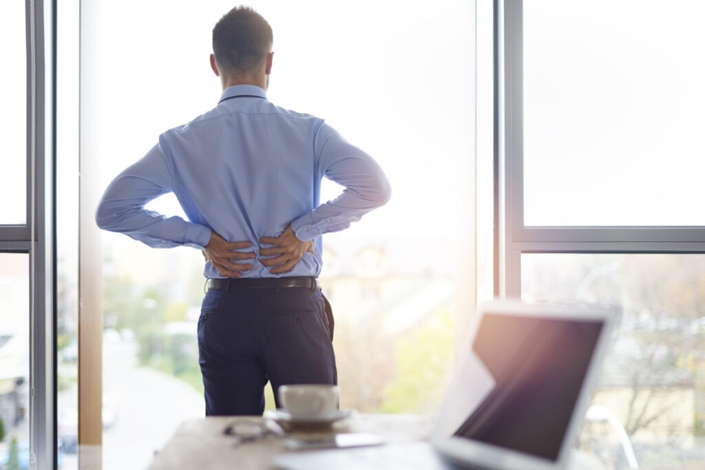 A business person holding is back due to back pain